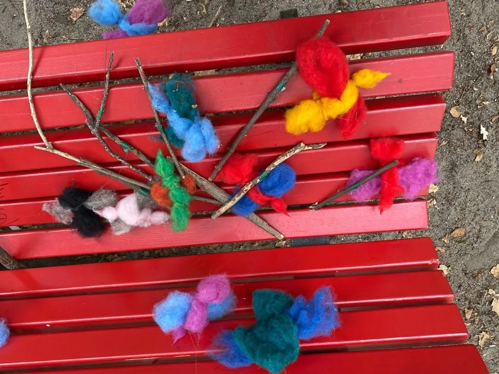 Bunte Bastelarbeiten auf einer roten Bank