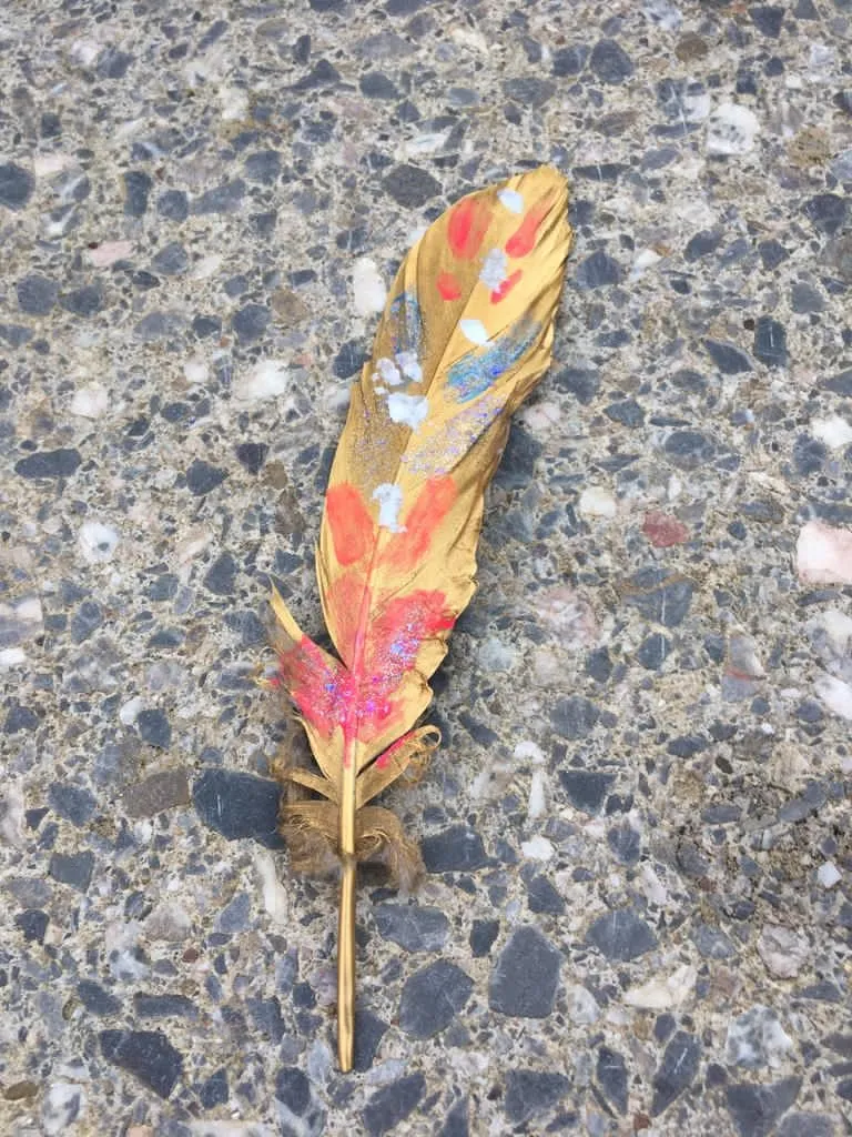Gebastelte bunte Feder aus Herbstlaub
