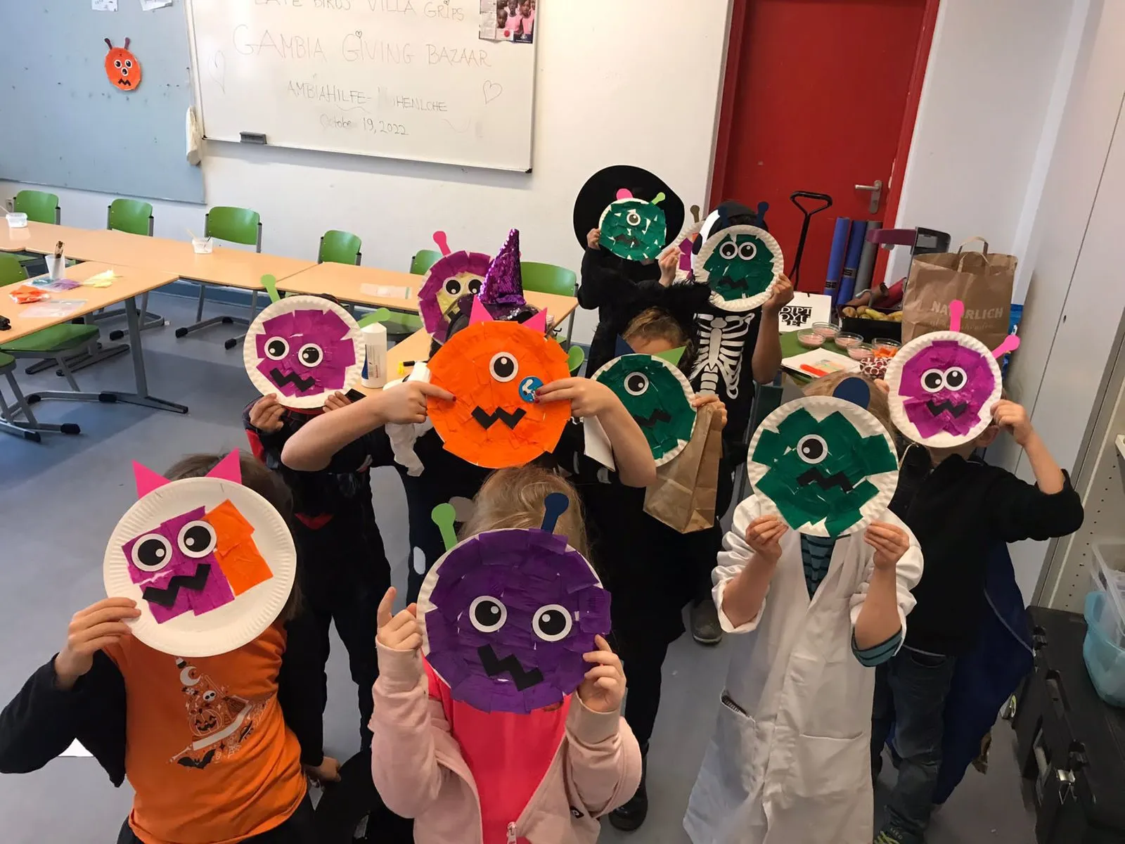 Kinder zeigen selbst gebastelte Masken