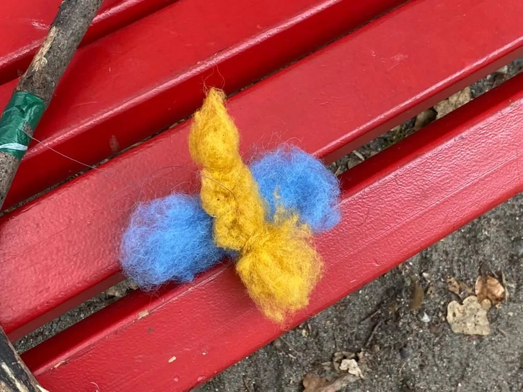 Pompom-Bastelei auf einer roten Bank