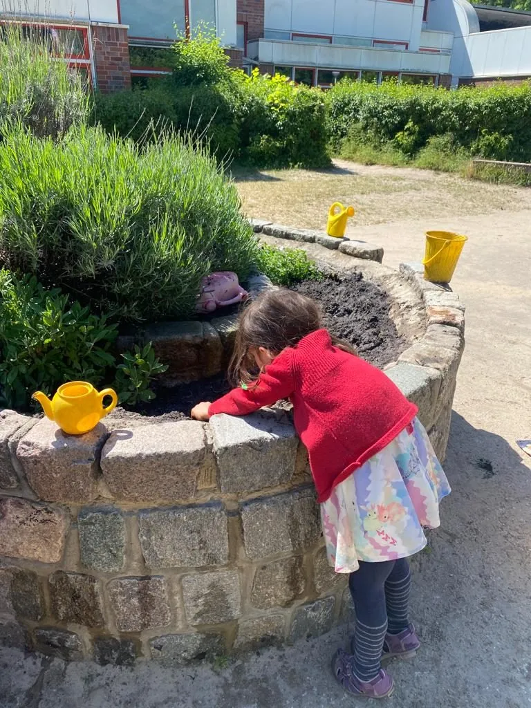 Kind an der Wasserstelle im Garten