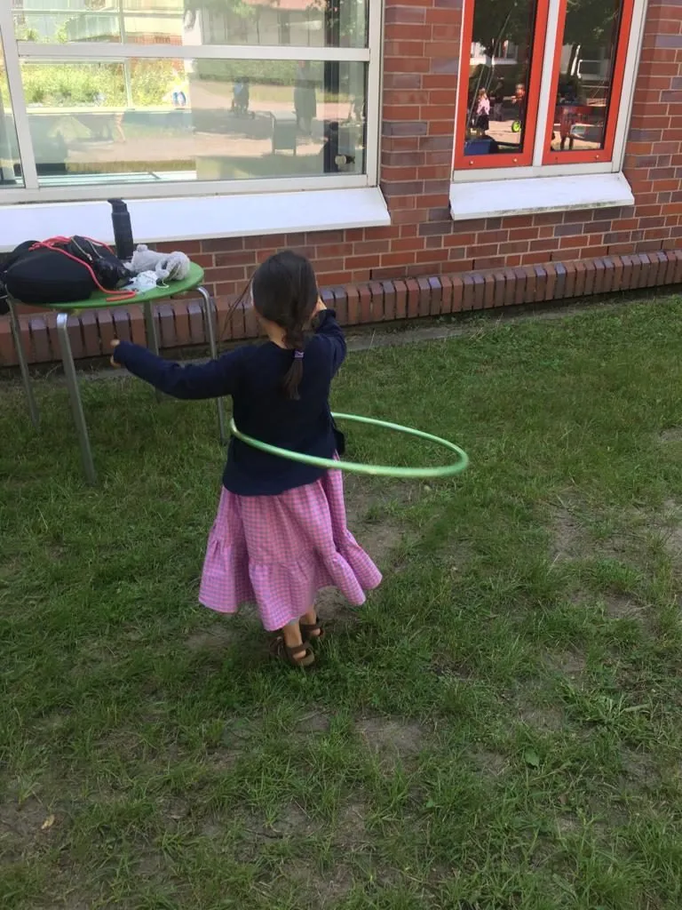Kind mit Hula-Hoop-Reifen auf der Wiese