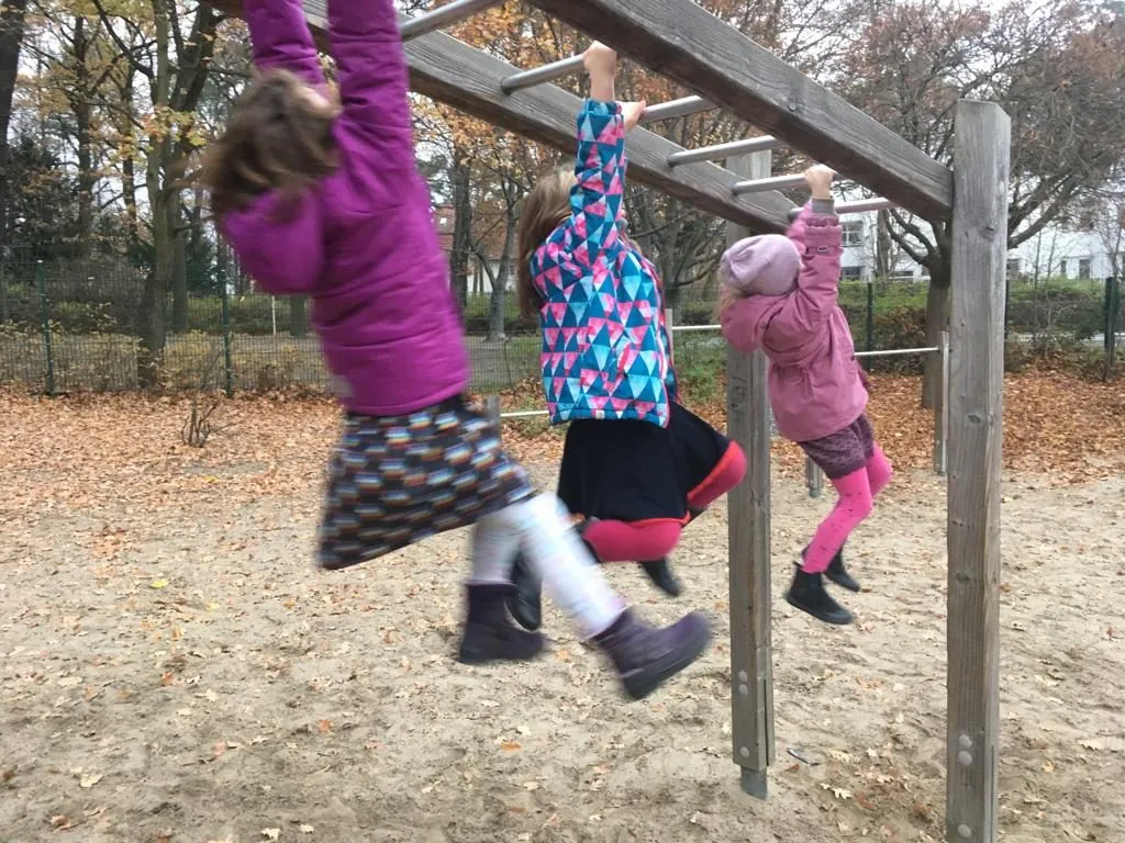 Kinder klettern auf dem Spielplatz der Nachmittagsbetreuung
